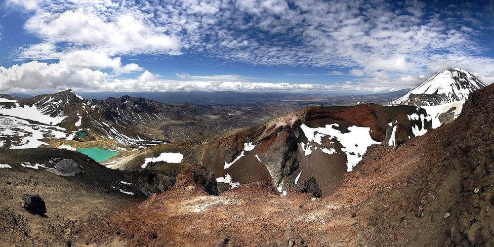 Hikers on the Tongariro Alpine Crossing above volcanic lakes.