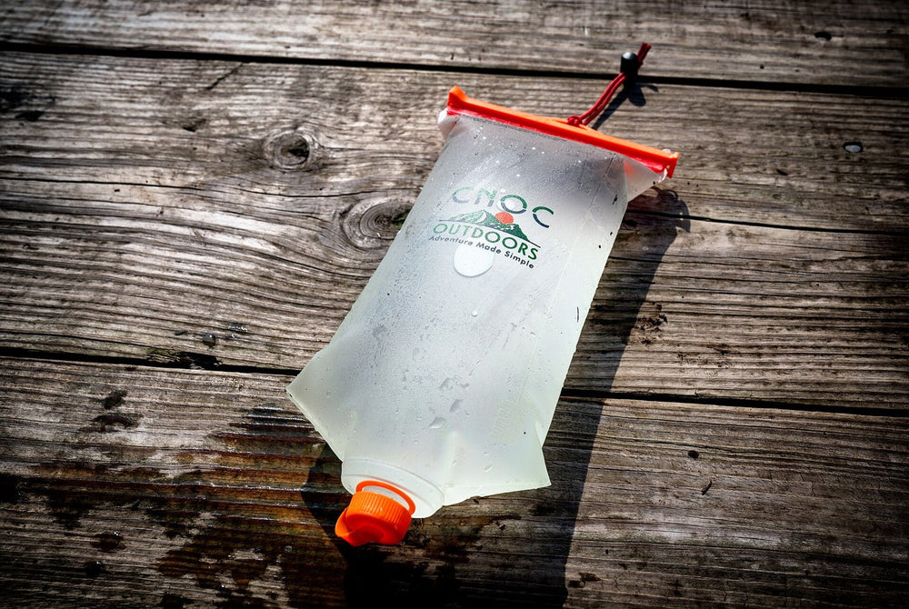 A collapsible two-litre water container on a wooden table.