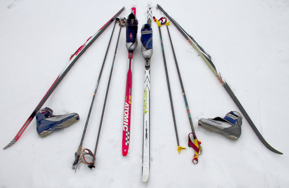 Cross-country skis, boots, bindings and poles laid out together.