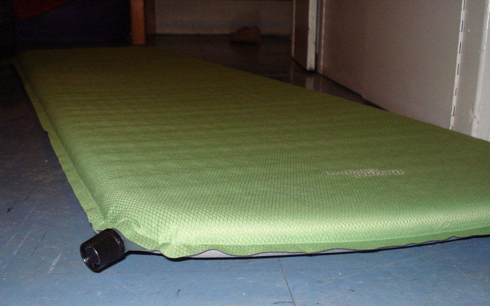 A self-inflating camping mat with its valve visible.
