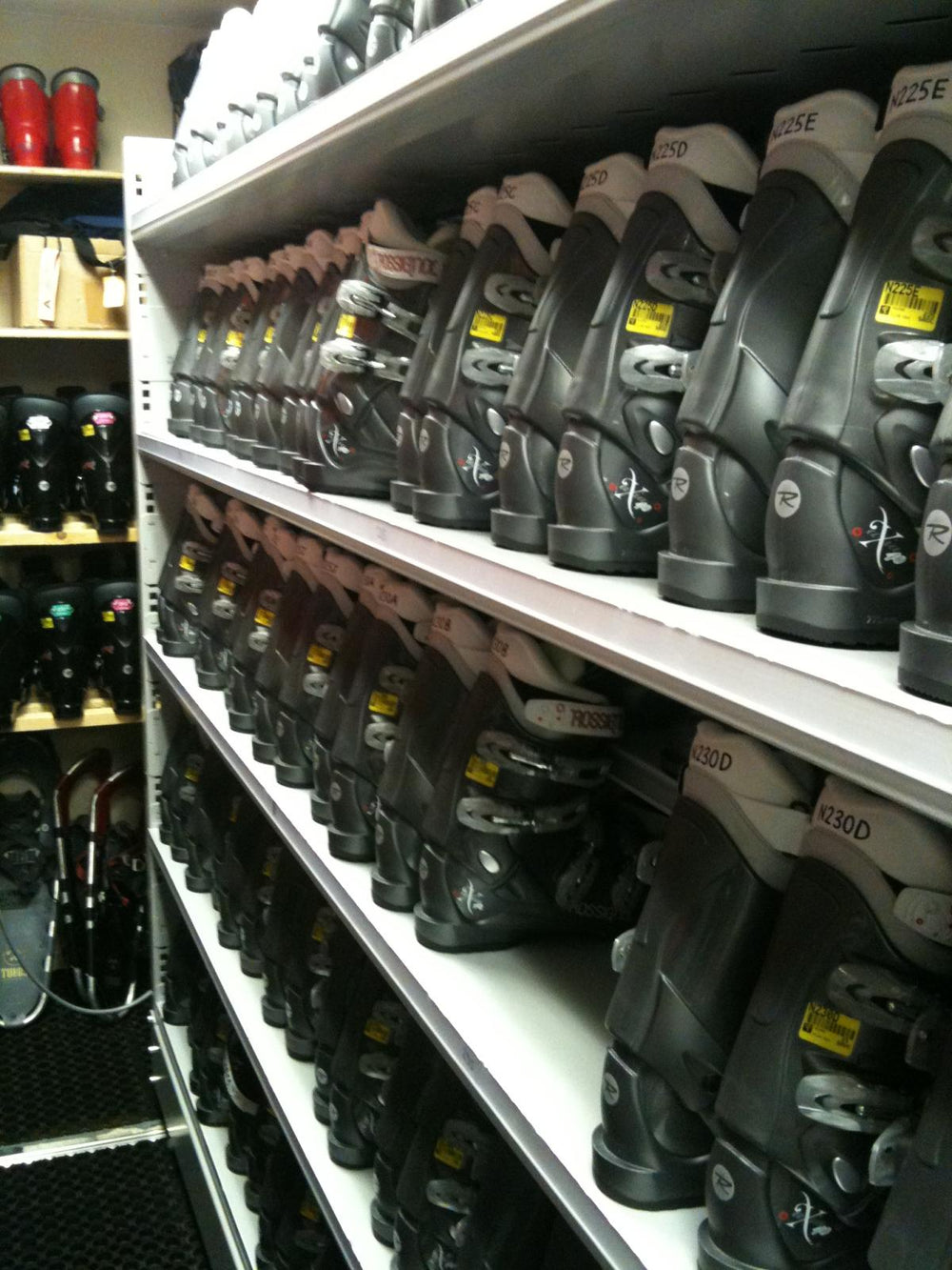 Rows of ski boots on shelves at a ski hire centre.