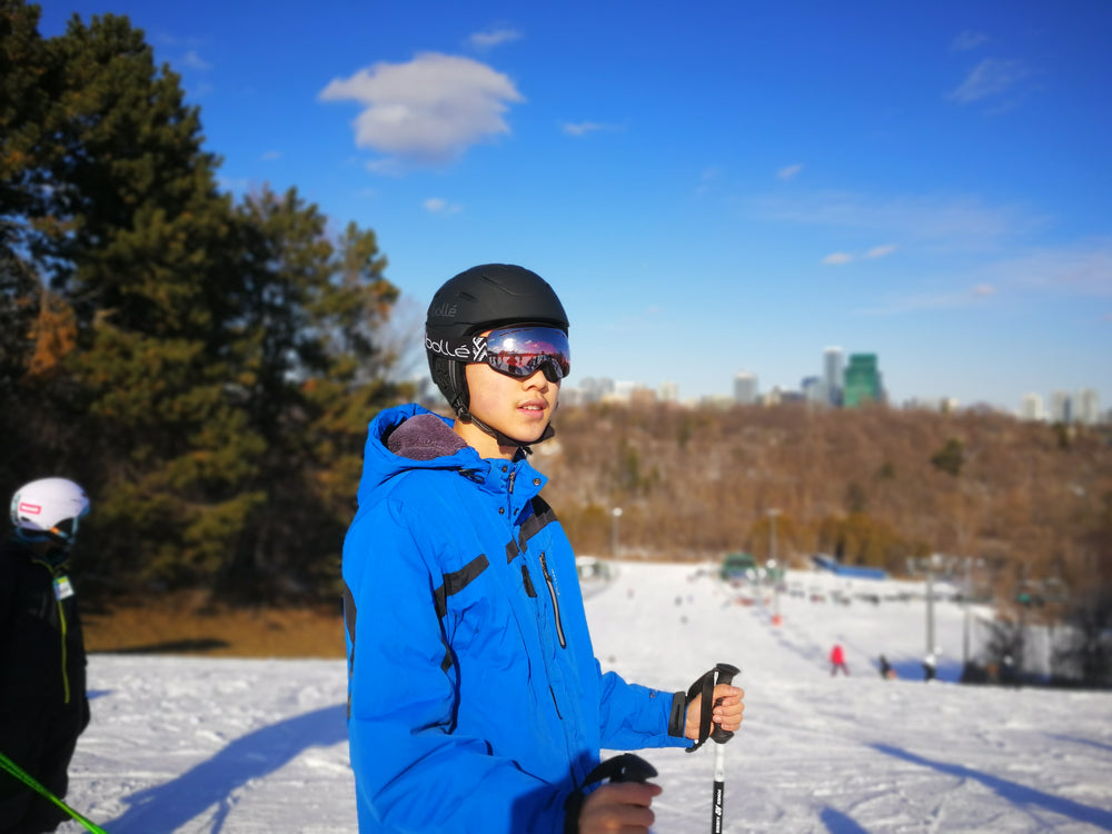 A skier wearing a blue jacket, helmet and goggles.