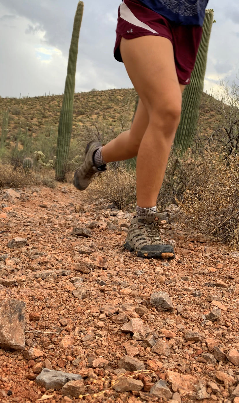 A trail runner moving along a rocky path.
