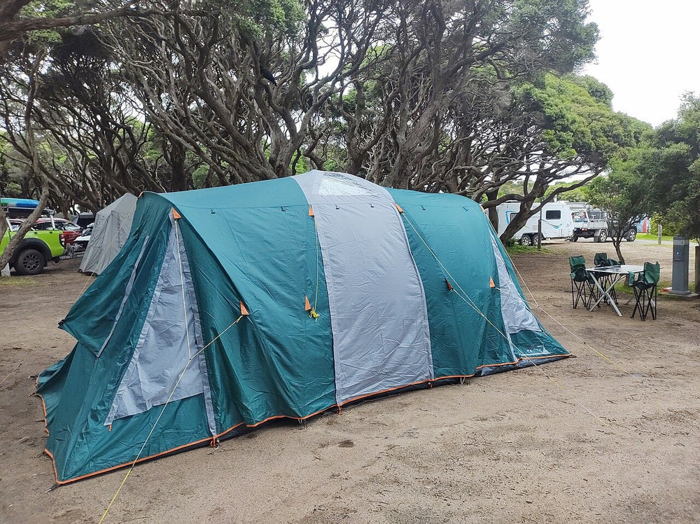 Large green family camping tent pitched on grass