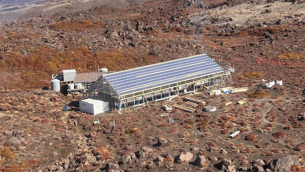 Oturere Hut under construction in the volcanic landscape. Photo: DOC.