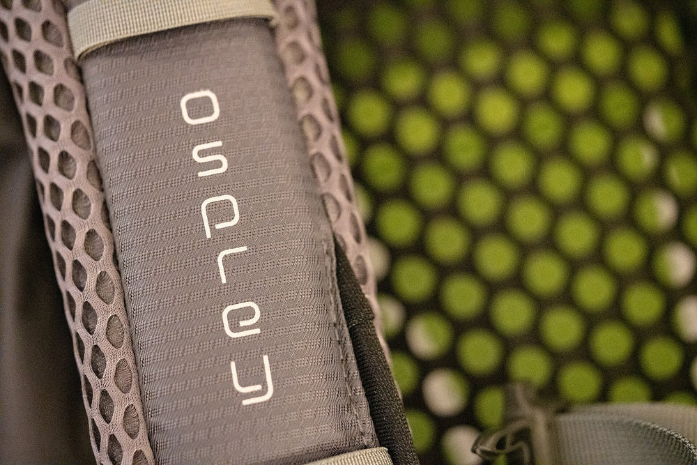Padded shoulder harness and mesh back panel of an Osprey Atmos backpack.