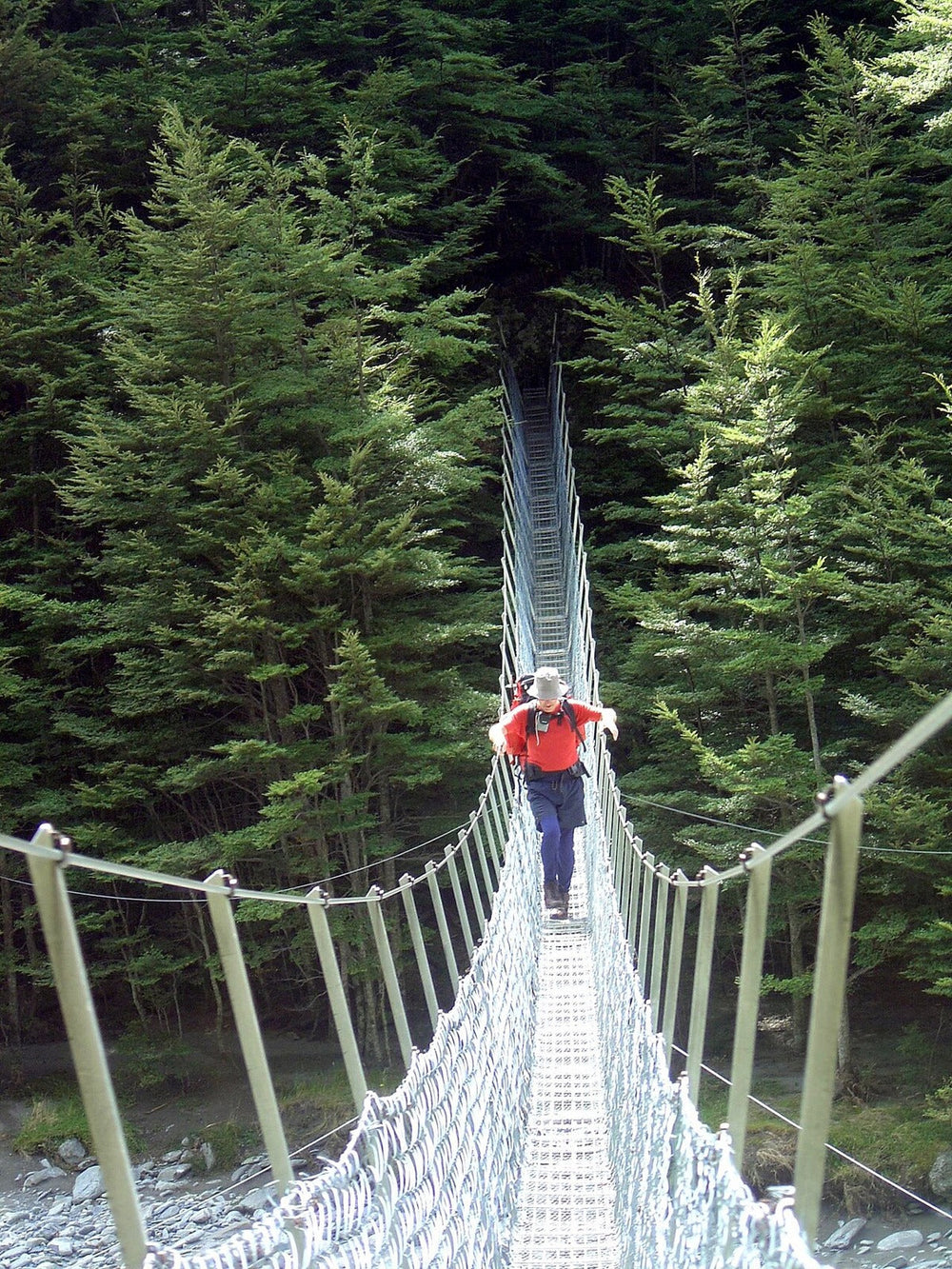 Walker using a swing bridge over the Huxley River