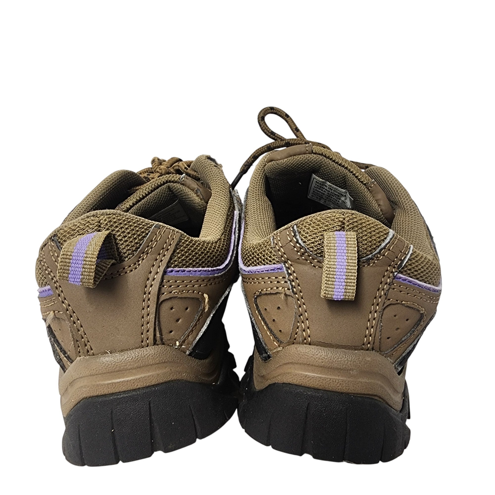 Pair of brown hiking shoes with black soles on a white background