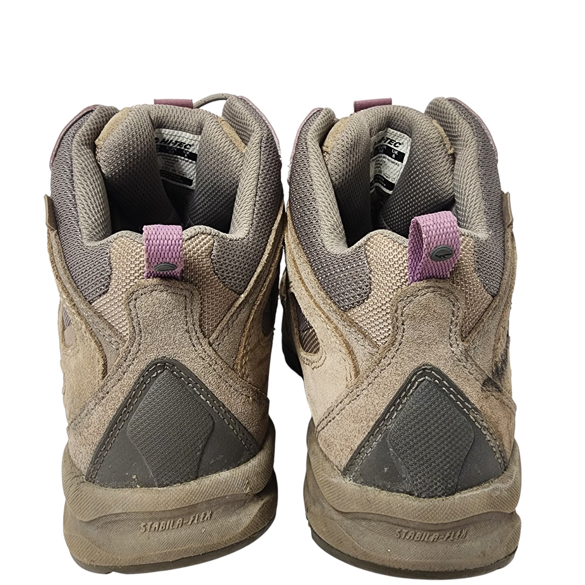 Pair of worn hiking boots on a white background