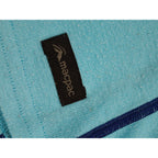 Label on Macpac aqua and navy long-sleeve base layer
