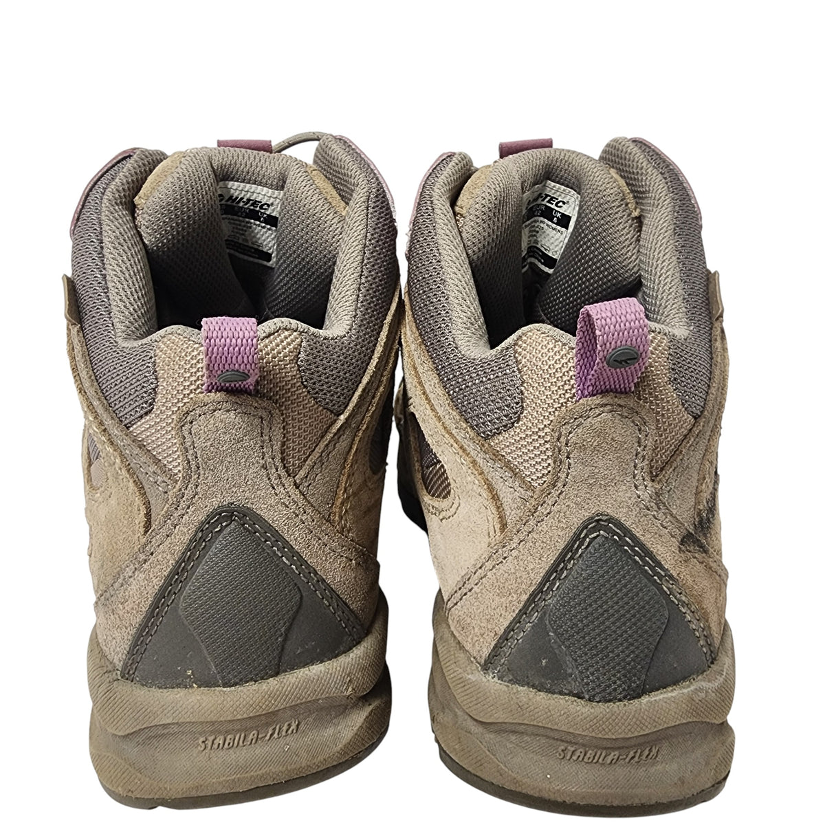 Pair of worn hiking boots on a white background